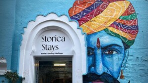 Ein Hostel namens 'Storica Stays' mit einem farbenfrohen Wandgemälde an der Außenfassade.