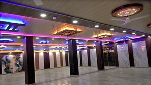 Un vestíbulo amplio con piso pulido, luminarias decorativas en el techo y paneles de pared de mármol.