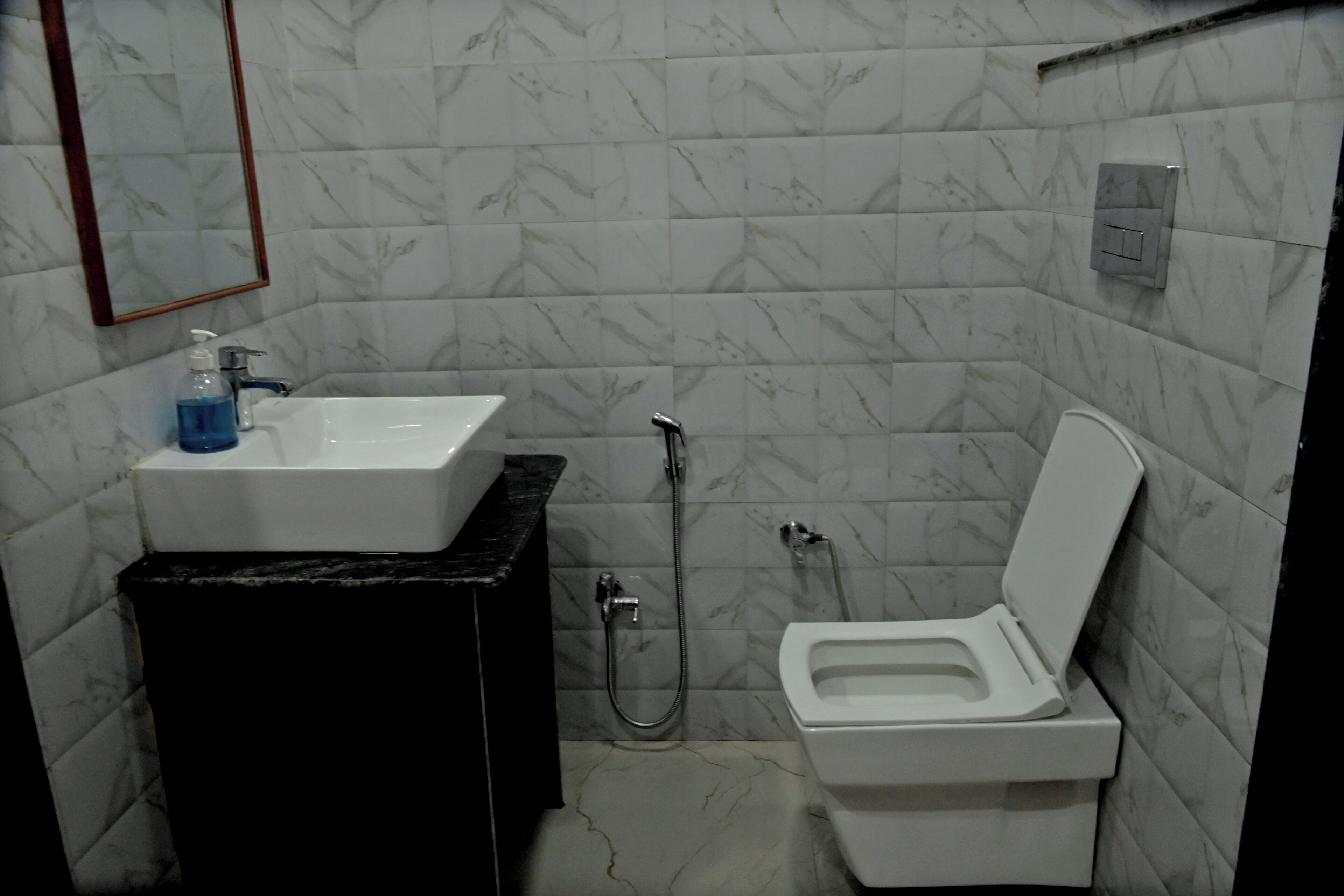 Un baño con lavamanos blanco, inodoro y ducha.