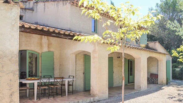 A rustic building with a patio area featuring a table and chairs. - Holiday rental - Maison Robert - La Tour D'Aigues, Location de vacances - Maison Robert - La Tour D' (La Tour-d'Aigues)