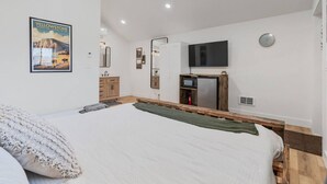 A bedroom with a bed, a TV, a mirror, and a poster on the wall. - #9 Yellowstone Cabin w/ AC, Fire Pit & BBQ! (Saint Charles)