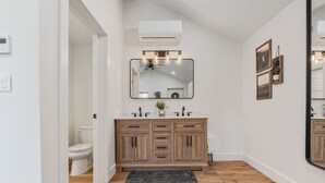 A modern bathroom with a wooden vanity, a large mirror, and a ceiling fan. - #9 Yellowstone Cabin w/ AC, Fire Pit & BBQ! (Saint Charles)