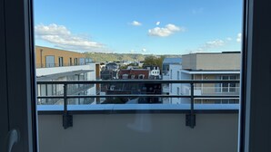 A view from a balcony with a clear sky, buildings in the distance, and a railing. - New apartment 5 minutes from Rouen's historic center - breathtaking view. (Rouen)