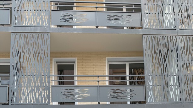 A multi-story building with a modern design, featuring balconies with decorative metal railings and a gravel courtyard. - New apartment 5 minutes from Rouen's historic center - breathtaking view. (Rouen)