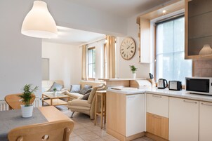 Una cocina moderna con microondas, tostadora y un reloj en la pared.