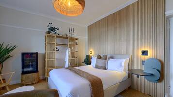 Een moderne hotelkamer met een groot bed, een televisie, een kledingkast en een nachtkastje.