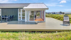 A modern house with a deck, a dining area, and a covered outdoor space. - 5 Star Holiday Home in Lokken (Lokken)