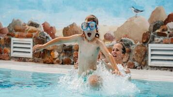 Una piscina con una persona saltando al agua.