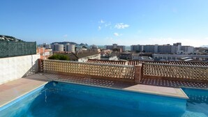 A swimming pool with a view of a cityscape and a distant island. - Apartment in Spain Near Sandy Beach (Torroella de Montgrí)