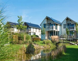 A modern residential building with a water feature in the foreground. - Family Villa by the Lake (Froidchapelle)