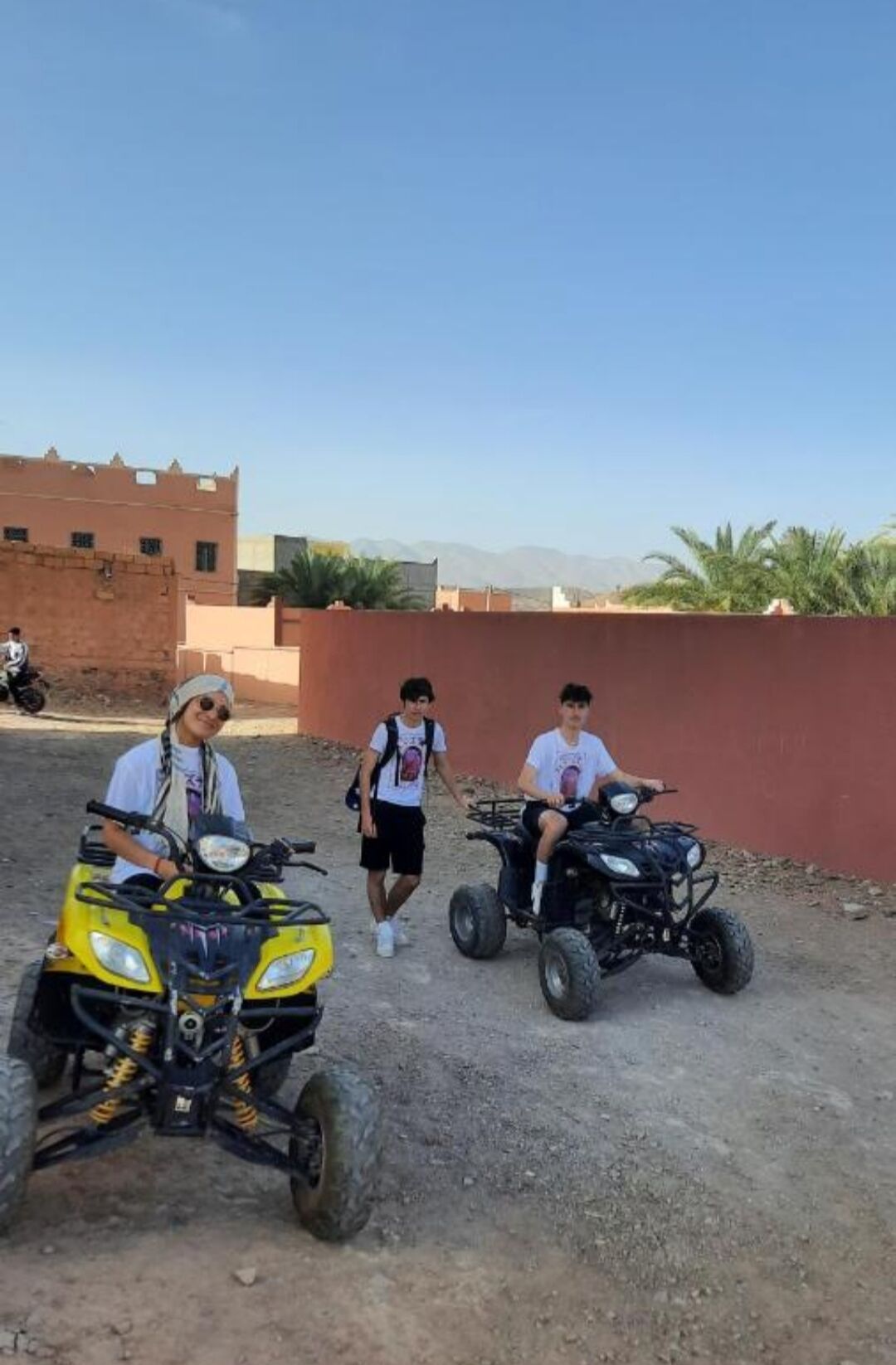 Un groupe de personnes à bord de quads dans un paysage désertique, sous un ciel dégagé.