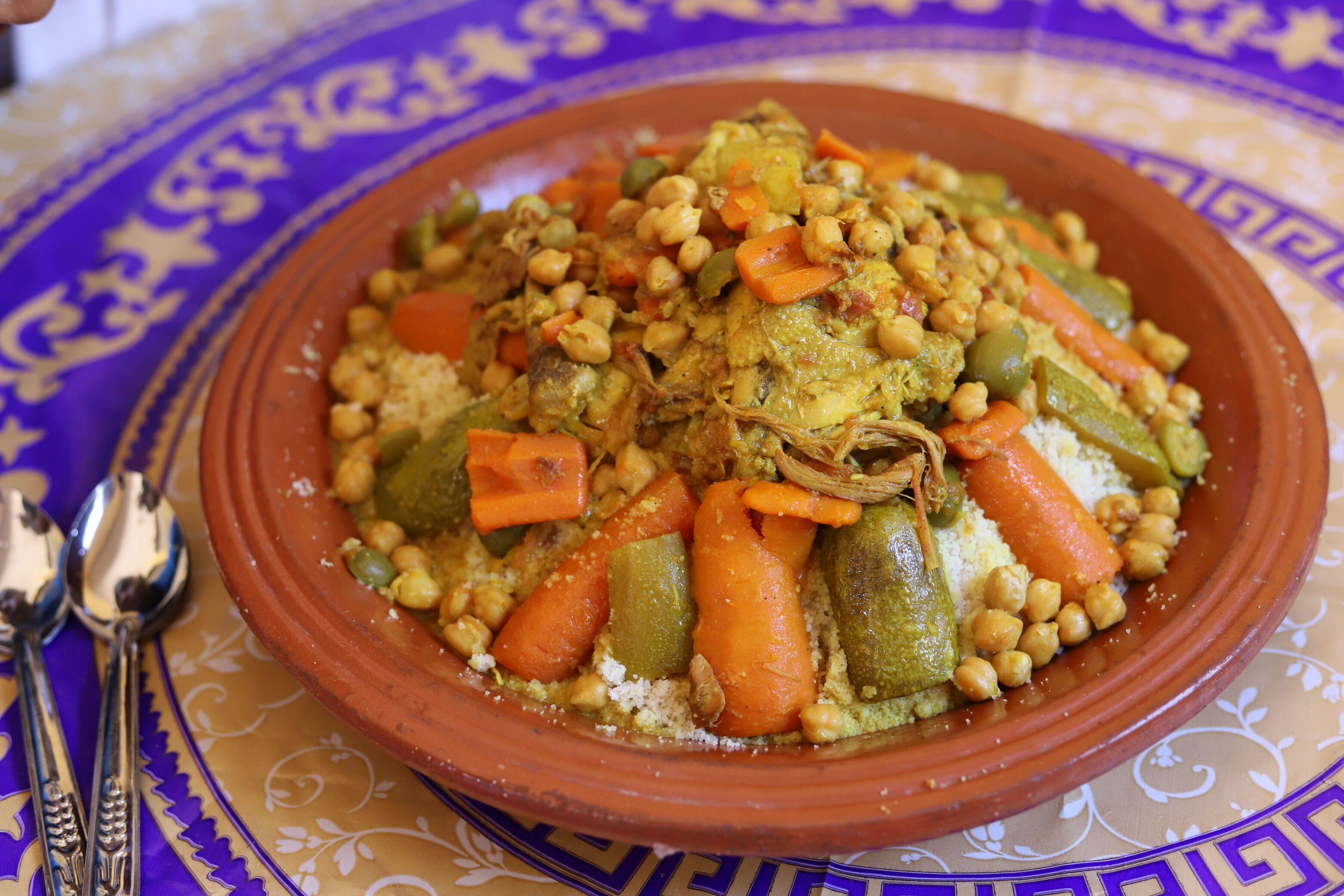 Plato tradicional marroquí de tagine, servido en una olla de barro, con garbanzos, zanahorias y calabacín.