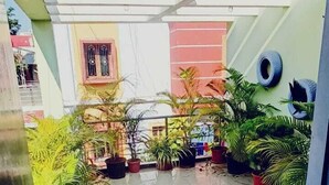 An indoor courtyard with potted plants and a tiled floor. - The Basic (Bhubaneshwar)