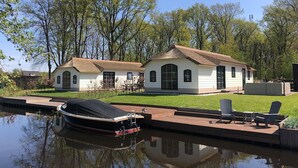 Een huis met een steiger en een boot.