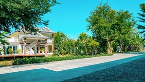 A large, two-story house with a covered porch and a staircase leading to the upper floor. - Farinda Resort & Pool Villa (Chom Thong)