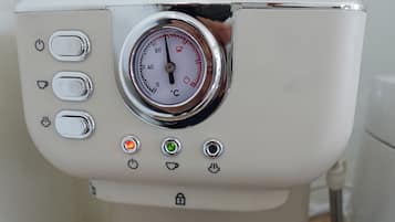 A coffee machine with a digital temperature gauge, control buttons, and a water reservoir.