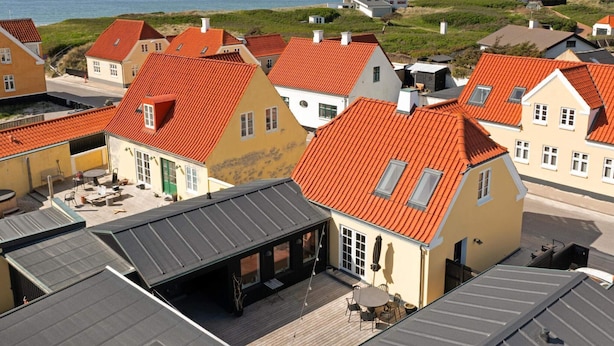 A coastal village with traditional houses featuring red-tiled roofs and a view of the sea. - 5 Star Holiday Home in Lokken (Lokken)