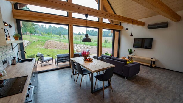 A spacious kitchen with a dining area, large windows, and a view of the countryside. - Apartment Near Pernstejn Castle in Smrcek (Býšovec)