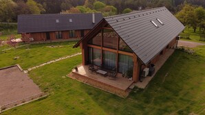 A modern house with a large porch, a covered outdoor seating area, and a sloped roof. - Apartment Near Pernstejn Castle in Smrcek (Býšovec)