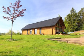 A modern wooden building with a sloped roof, large windows, and a well-maintained lawn. - Apartment Near Pernstejn Castle in Smrcek (Býšovec)