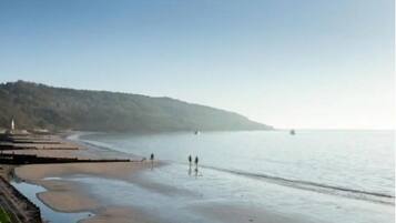 Enjoy a serene beach experience with a gentle slope leading to the calm sea.