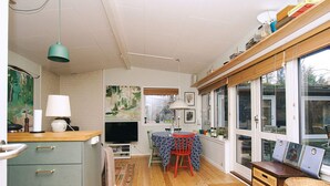 A compact living space with a kitchen, dining area, and large windows. - 4 Person Holiday Home in Frederiksvaerk (Frederiksvaerk)