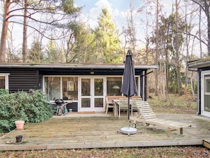A cabin with a deck, outdoor seating, and a grill area. - 4 Person Holiday Home in Frederiksvaerk (Frederiksvaerk)