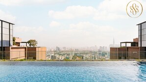 Ein Dachpool mit Infinity-Kante und Blick auf die Stadt, moderne Gebäude und ein klarer Himmel.