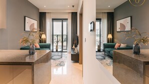 Ein modernes Hotelzimmer mit einem großen Fenster, einem grünen Sofa, einem Marmor-Couchtisch und einem kleinen Beistelltisch.