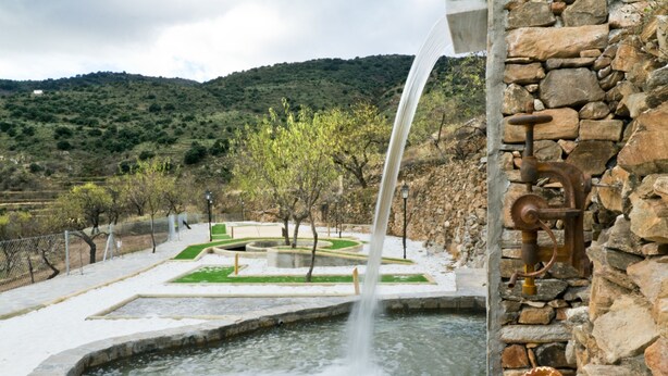 A fountain with water flowing into a pool, surrounded by stone walls and greenery. - romantic house for 2 people with jacuzzi (Laroya)