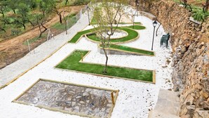 A landscaped garden with a stone wall, a winding path, and a central tree. - romantic house for 2 people with jacuzzi (Laroya)