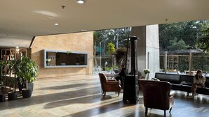 Un'ampia hall con reception, area salotto e ampie finestre che offrono vista sull'esterno.