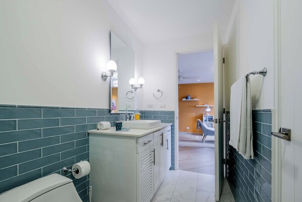 A modern bathroom with a white sink, a mirror, and a towel rack.