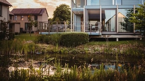A modern two-story house with a large glass window and a balcony. - Serene Luxe Lakeside Stay (Froidchapelle)