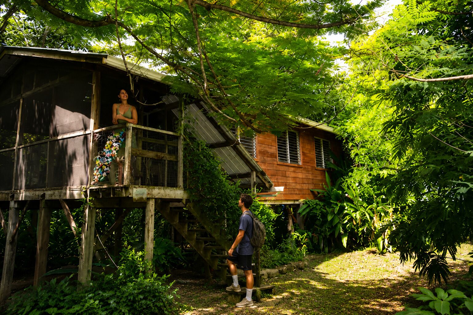 A wooden house with a balcony and a staircase leading to a raised platform.