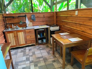 Una cocina compacta con muebles de madera, una estufa a gas y un lavamanos.