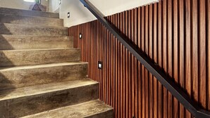 A staircase with wooden steps and a wooden panel wall. - Spacious 8-Bedroom House in Central Guadalajara (Guadalajara)