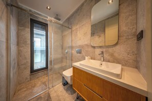 A modern bathroom with a glass shower enclosure, a wooden vanity, and a large mirror. - Luxurious Villa Retreat With Private Swimming Pool (Bodrum)
