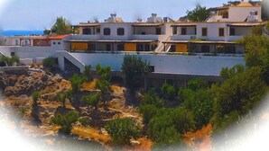A coastal building with multiple levels, featuring balconies and a mix of architectural styles. - Southern Crete, Filoxenia Villa, is a group of ten holiday apartments (Koutsounari)
