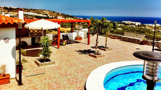 A rooftop pool area with a clear view of the sea, a covered seating area, and potted plants. - Southern Crete, Filoxenia Villa, is a group of ten holiday apartments (Koutsounari)