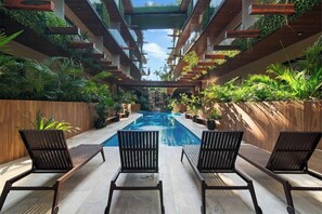 A pool area with lounge chairs, a clear view of the pool, and greenery on the walls. - Vibra Bonito Luxe Boho-chic Hideaway in Tulum (Tulum)
