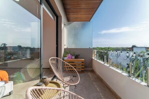 A balcony with a glass partition, a chair, a small table, and a neon sign. - Vibra Bonito Luxe Boho-chic Hideaway in Tulum (Tulum)