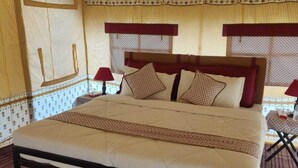 A bed with a headboard, a bedside table, and a lamp. - Kumbh Travel (Prayagraj)