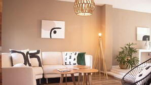 A modern living room with a sofa, two wooden side tables, a floor lamp, a chair, and a potted plant. - Charming House Rental in Zapopan, Mexico - Your Private Oasis (Zapopan)