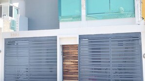 A modern building with a grey facade, a visible number '1484', and a balcony with a glass railing. - Charming House Rental in Zapopan, Mexico - Your Private Oasis (Zapopan)
