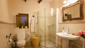 Ein Badezimmer mit Toilette, Dusche, Waschbecken und Spiegel.