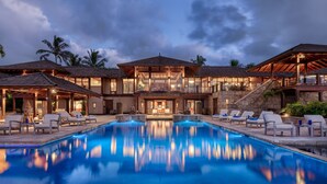 A large, multi-story resort with a central pool, multiple lounge areas, and a well-lit exterior. - Hale Ae Kai in Kilauea (Kilauea)