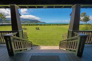 A wooden deck with a view of a well-maintained lawn and a body of water. - Hanalei Nalu in Hanalei (Hanalei)