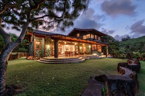A modern two-story house with a spacious patio, large windows, and a well-maintained lawn. - Sea Song in Kilauea With 4 Bedrooms and 6 Bathrooms (Kilauea)
