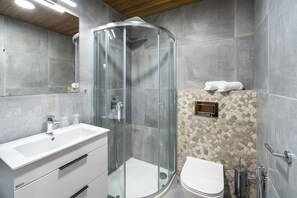 A modern bathroom with a glass-enclosed shower, a white sink, and a mosaic-patterned wall. - Villa in Cerny Dul With Pool & Sauna (Cerny Dul)